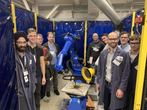 Group of people posing with manufacturing equipment