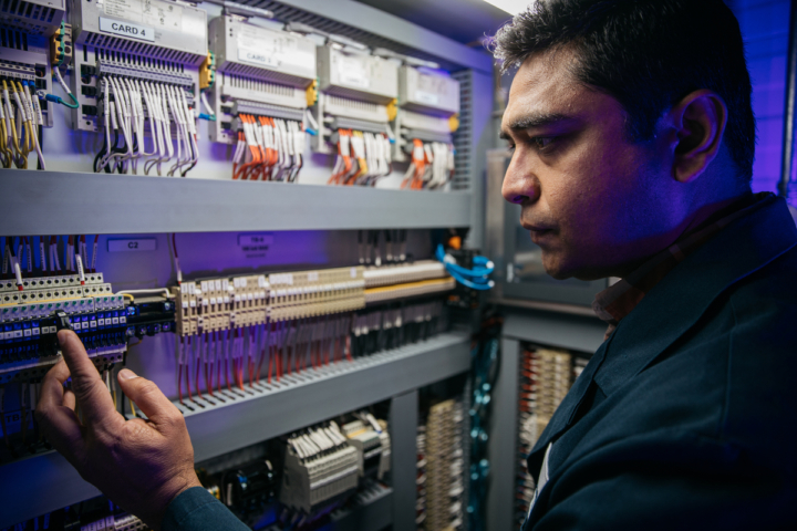 An InnoTech worker checking electronics