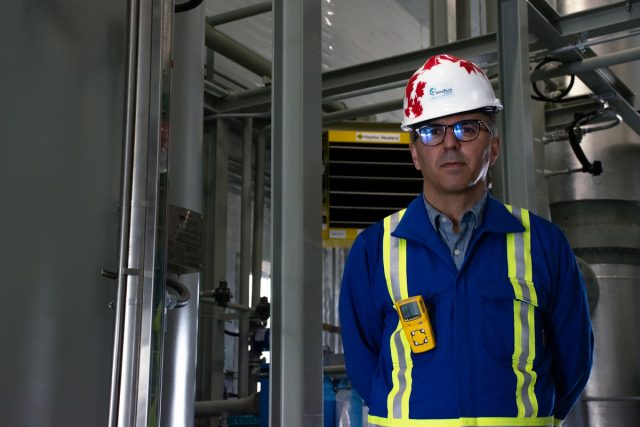 Man wearing hardhat and blue work jumpsuit