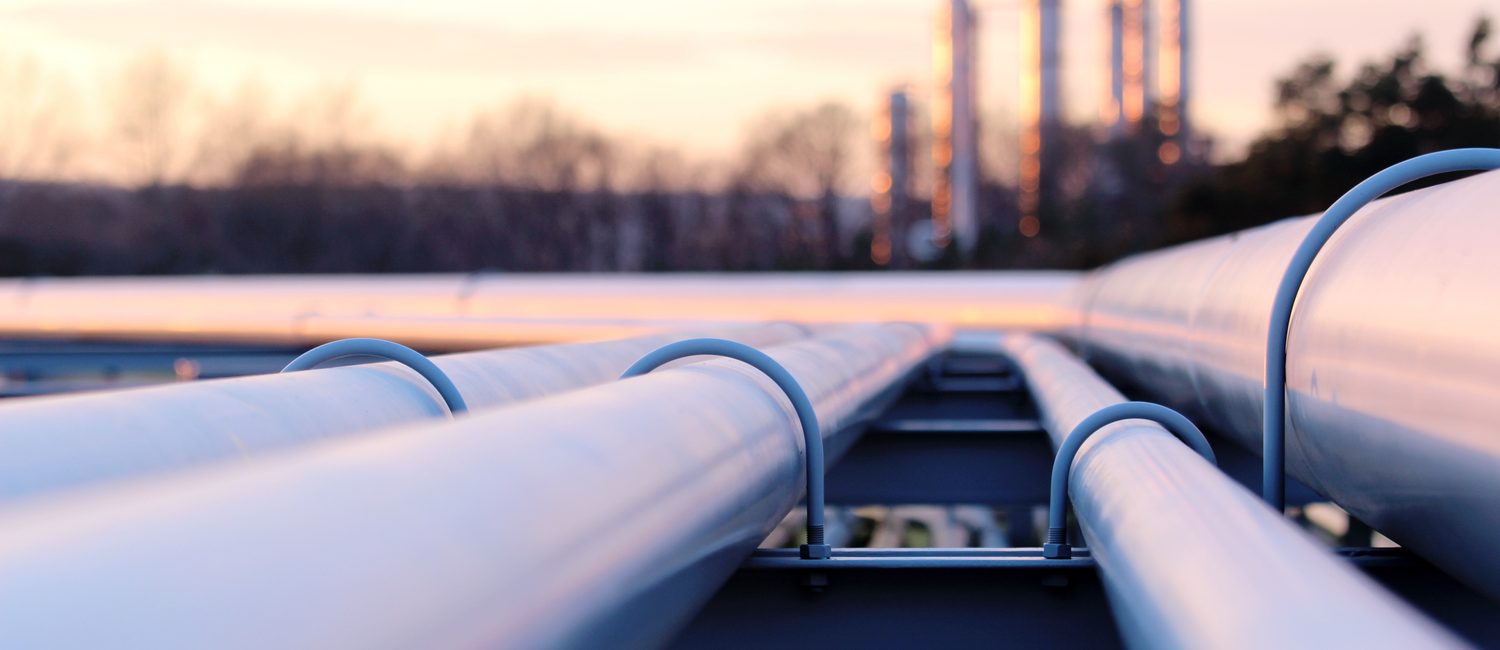 Pipelines at an oil refinery at sunset