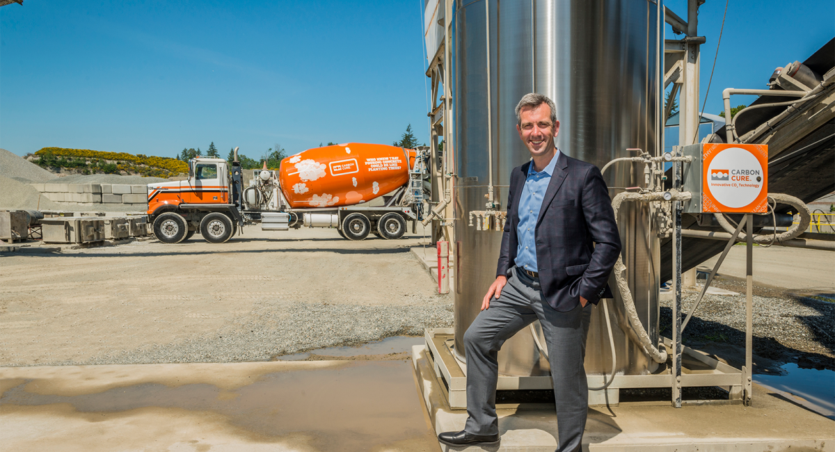 Rob Niven stands in front of a valve box and orange concrete truck