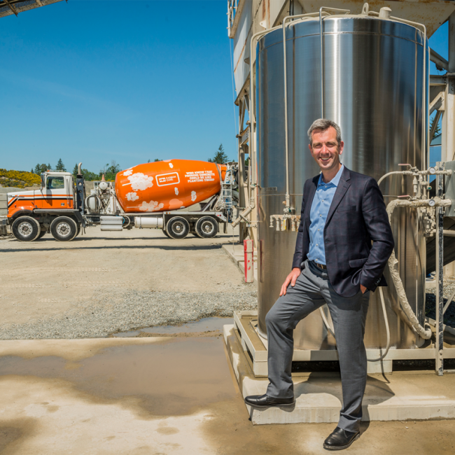 Rob Niven stands in front of a valve box and orange concrete truck